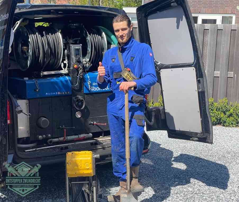 Een tevreden monteur met opgestoken duim naast de bestelbus, slim ingrijpen bespaart kosten bij een verstopte afvoer in Zwijndrecht