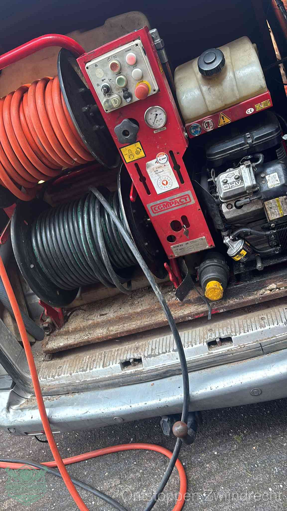 Een rood hogedruk-rioolreinigingstoestel in de laadbak van de bedrijfsbus, apparatuur voor een hardnekkige afvoerverstopping in Zwijndrecht