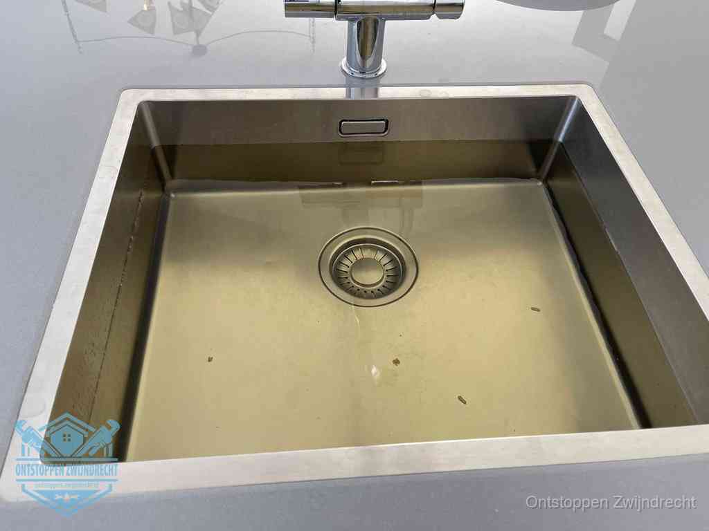 Stilstaand water in een rvs spoelbak dat niet wegloopt, een duidelijk signaal van een gootsteenverstopping in Zwijndrecht