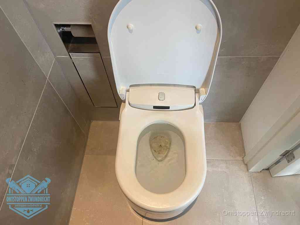 Een wit hangtoilet waarin een prop wc-papier op het water blijft drijven, een duidelijk signaal van een verstopte wc in Zwijndrecht