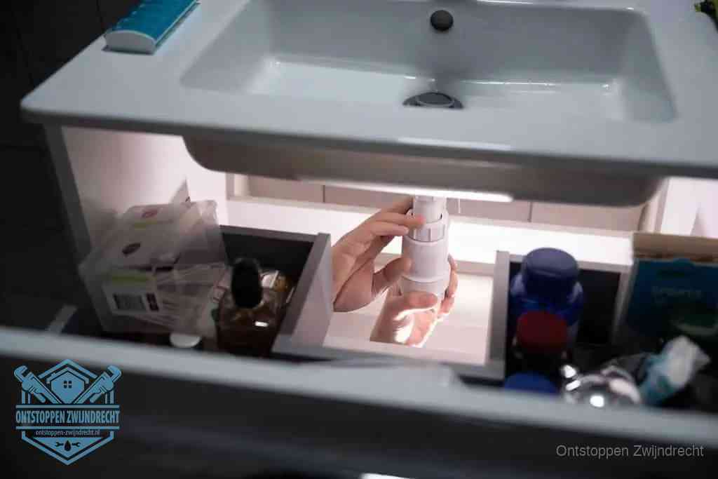 Een pompfles met zeep boven een wastafel in de toiletruimte, de warm water en afwasmiddel-methode om de wc te ontstoppen in Zwijndrecht